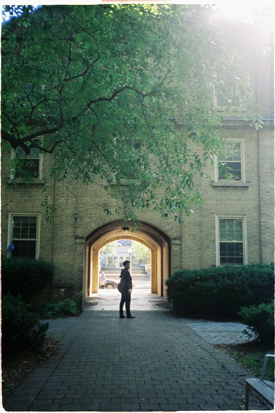 Huy Dang standing beneath a brick archway
